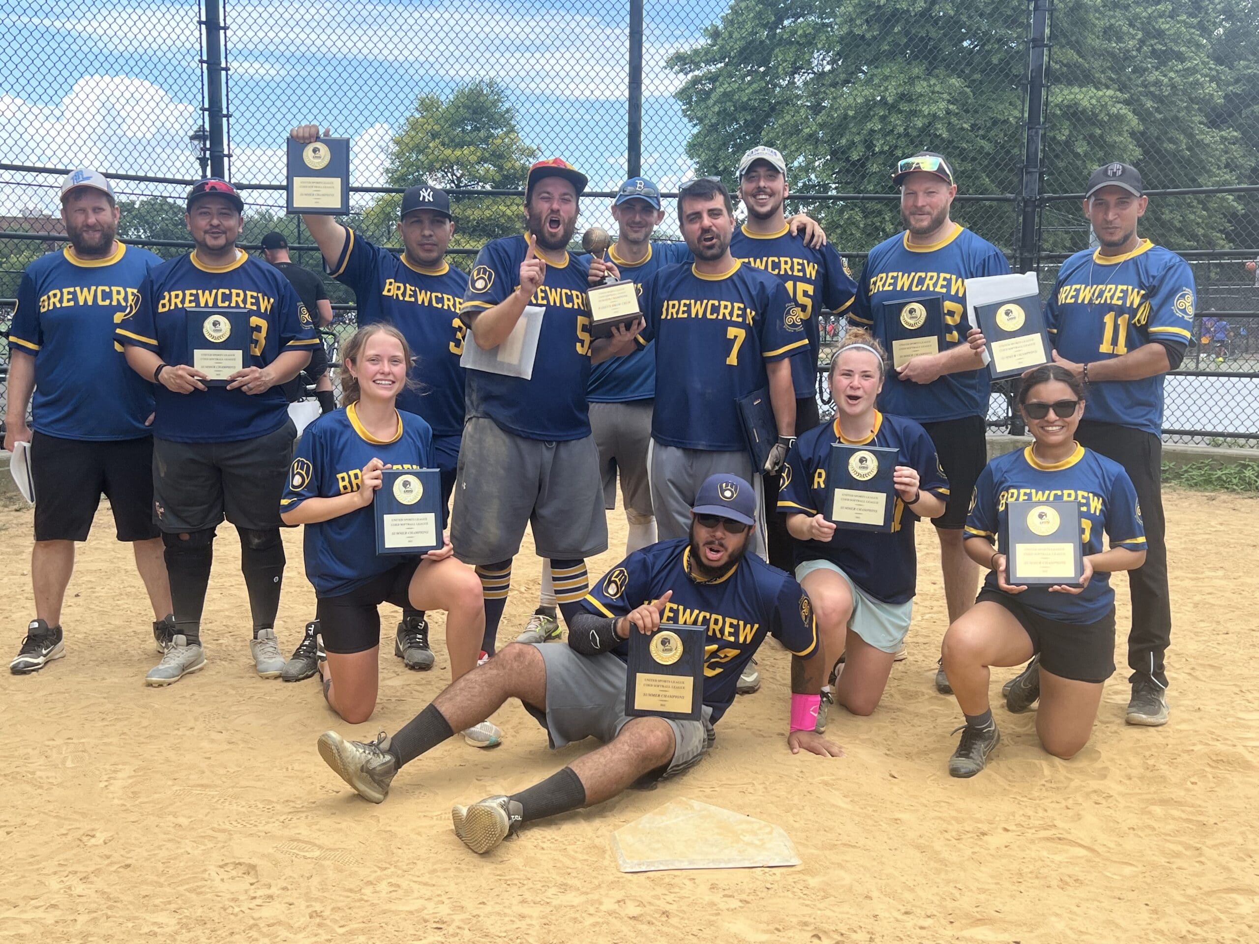 Softball team celebrating with plaques