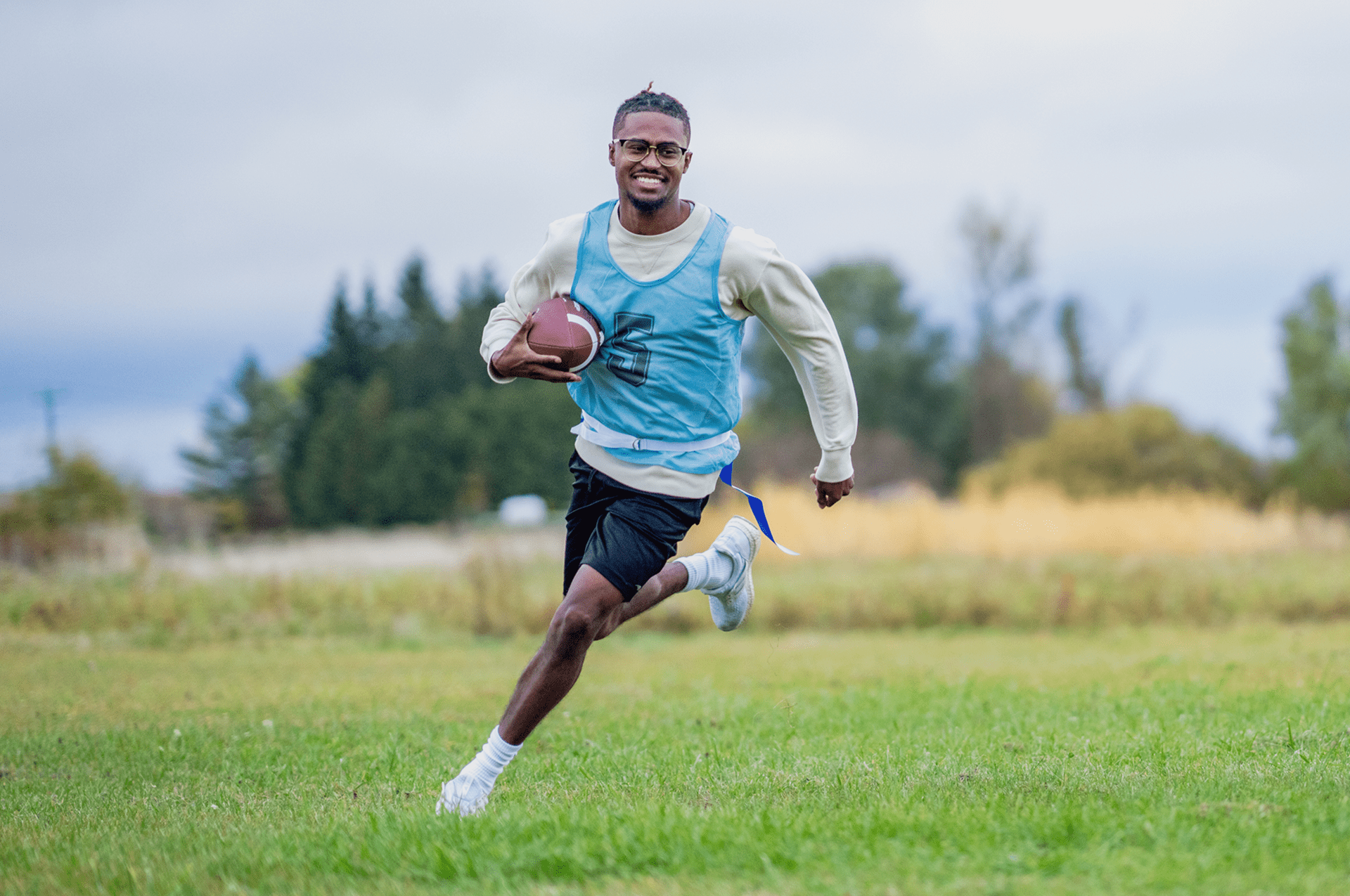 Man running with football in field