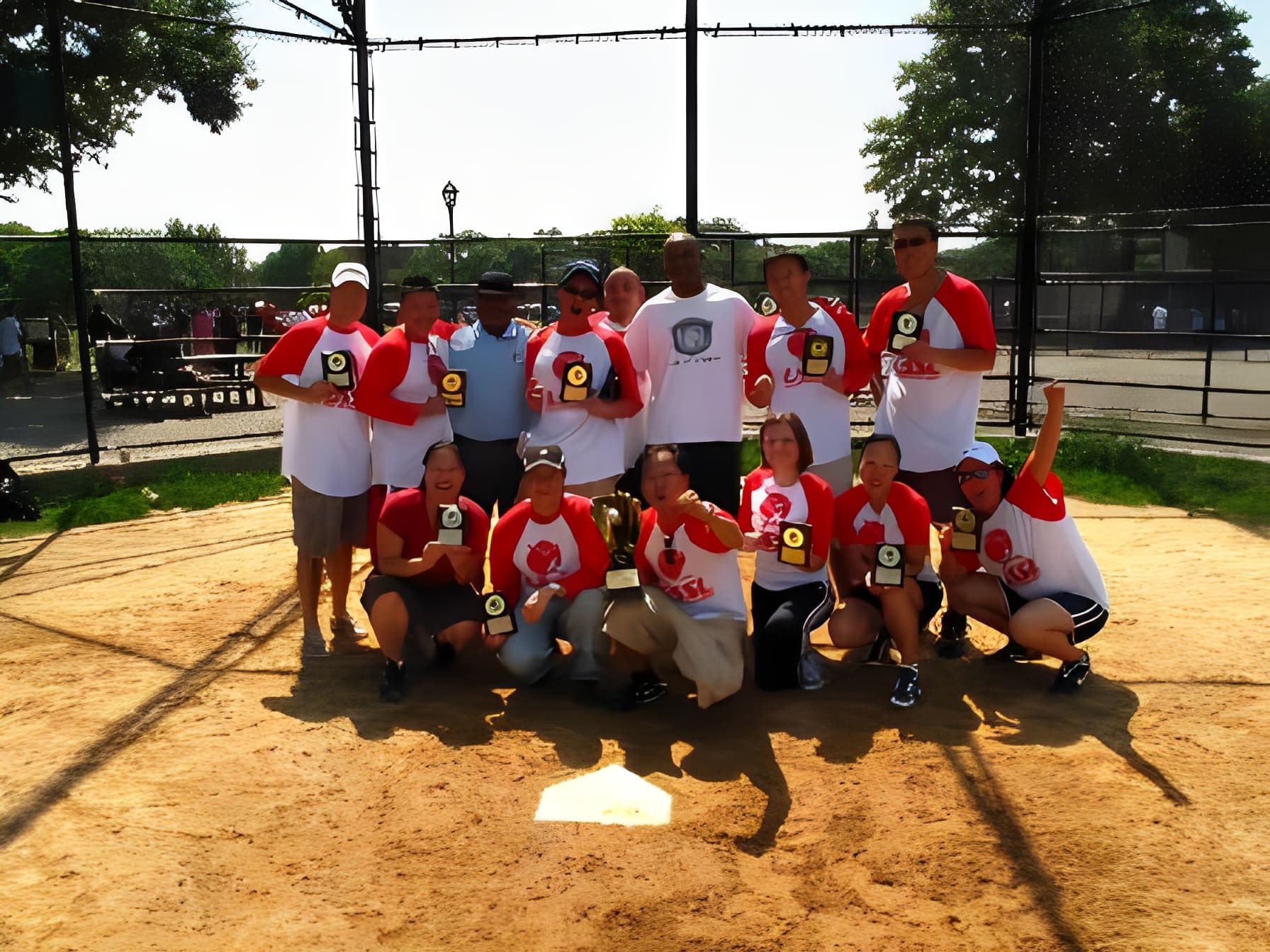 Softball team holding trophies on field