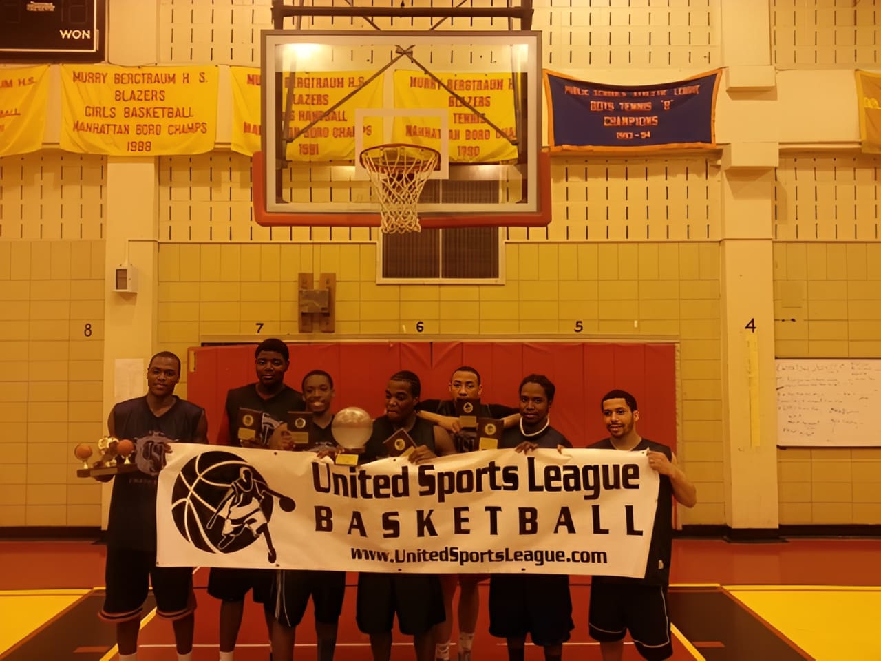Players celebrating with trophies and banner