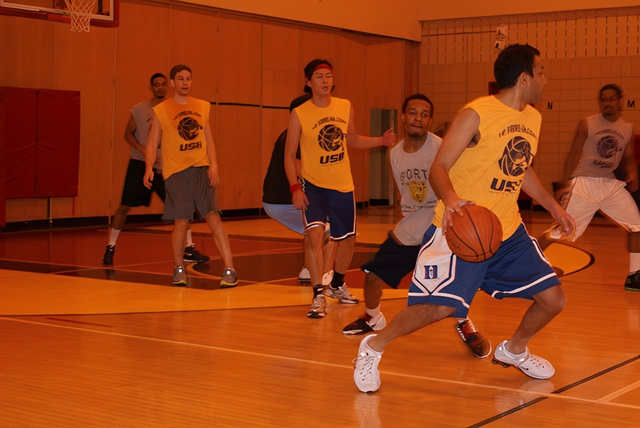 Team playing basketball in gym setting