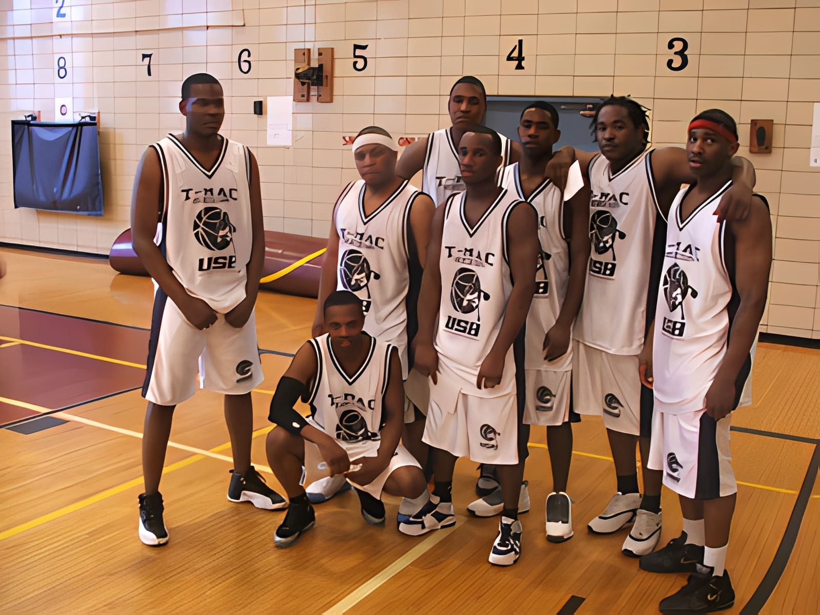 Basketball team posing on indoor court