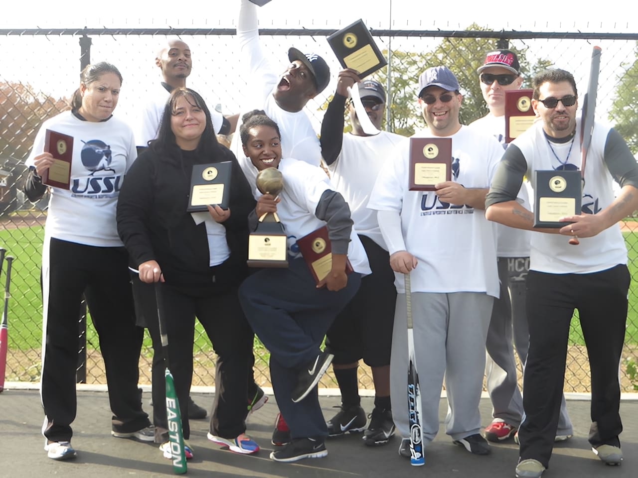 Team celebrating with trophies outdoors