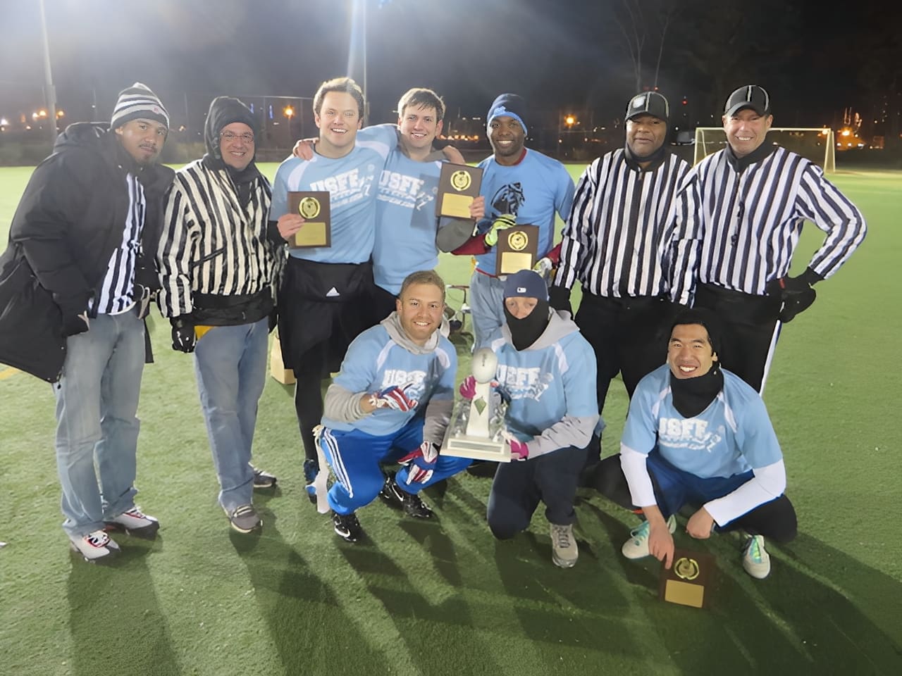 Team celebrating with trophy on field