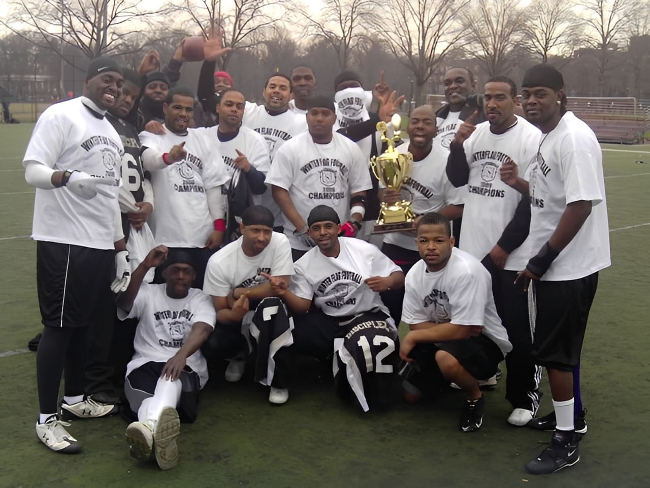 Team posing on field with golden trophy